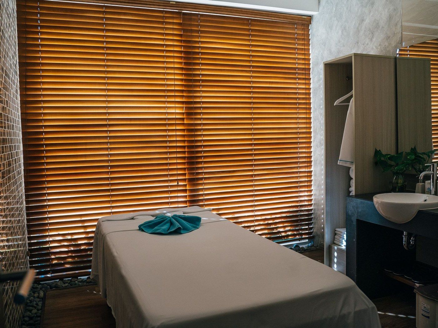 A treatment table by a window with wooden blinds