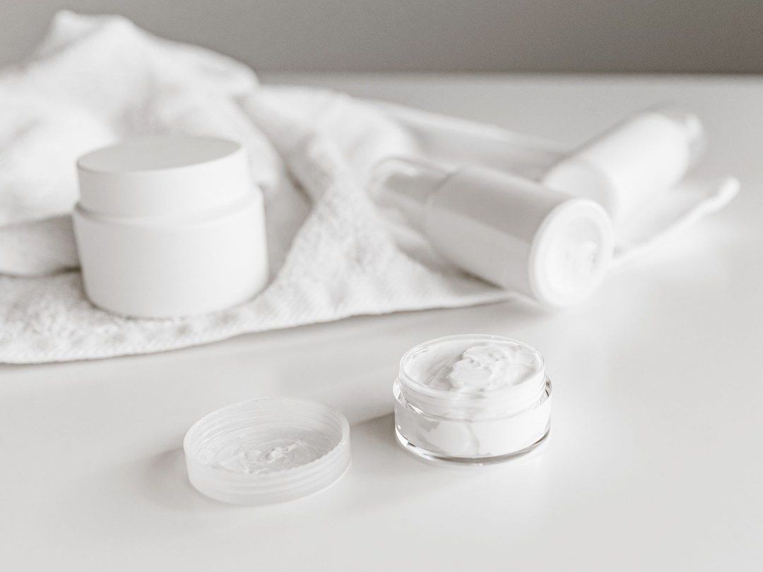 White skincare jars on a folded towel