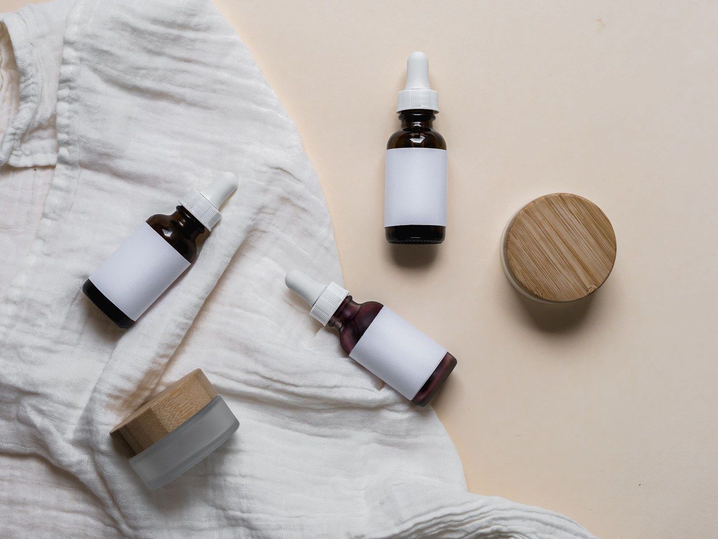 Glass bottles of treatment products on linen
