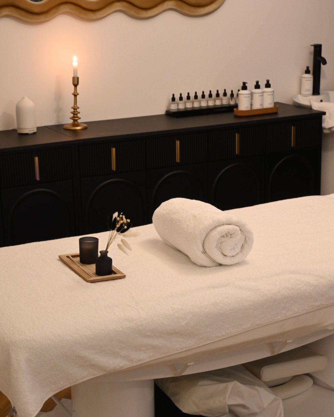 A treatment room with a rolled towel and a candle