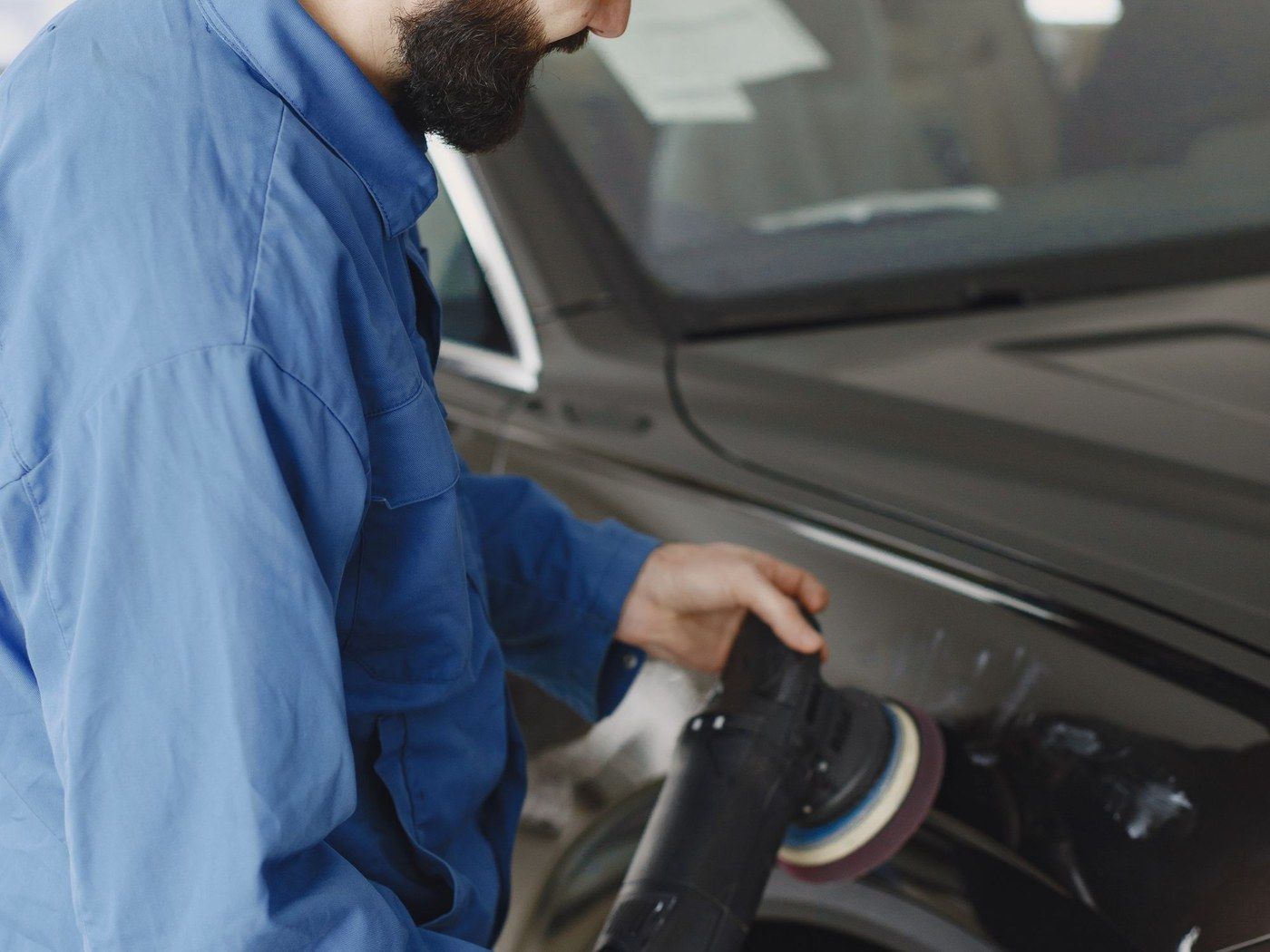 A technician polishing a car body