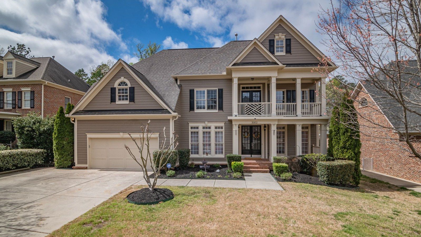 A two-story home with a gray shingle roof