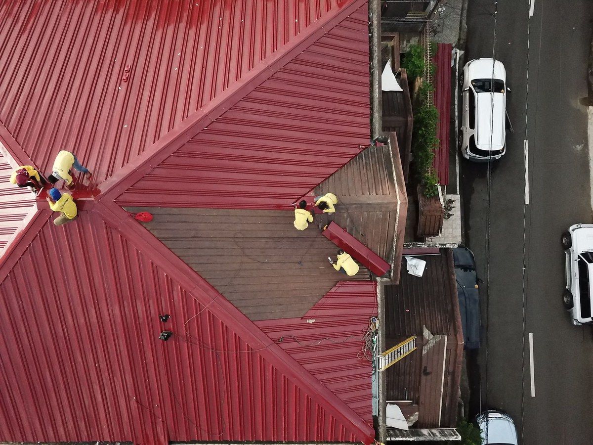A crew working on a metal roof, seen from above